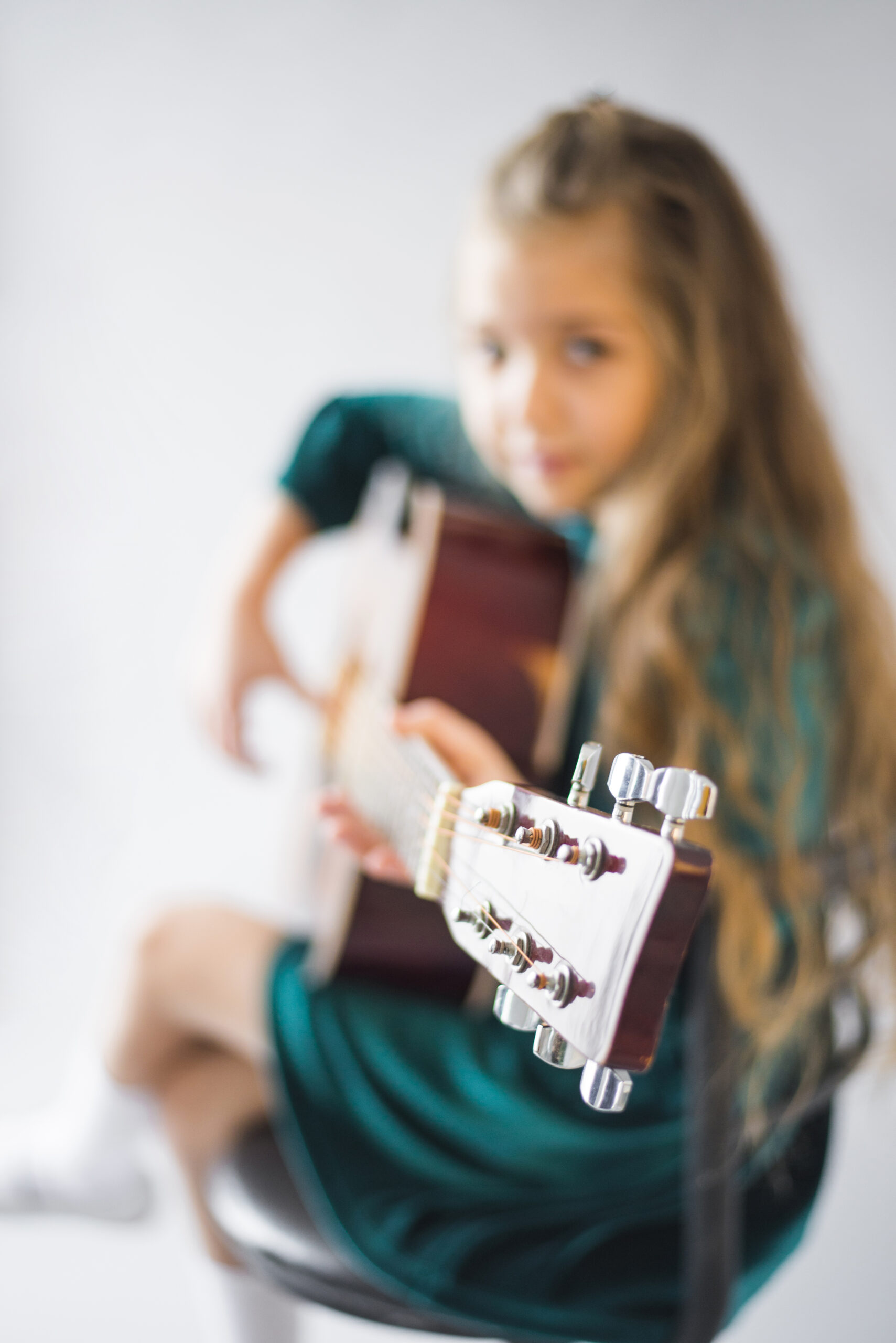 nina-en-vestido-verde-tocando-guitarra-acustica